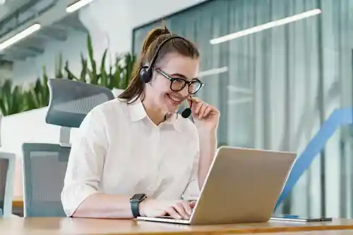 Customer service professional supporting a customer by headset and laptop