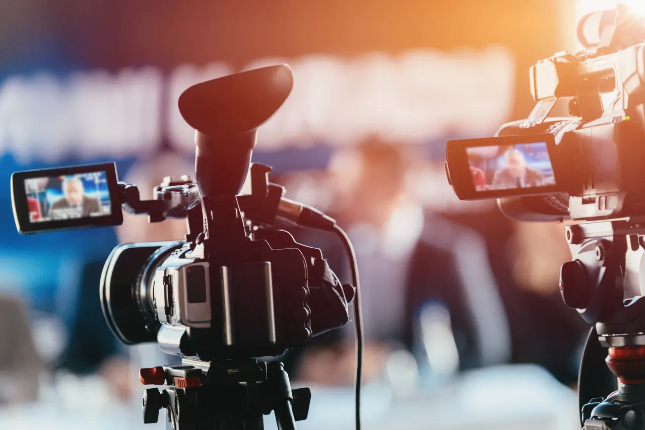 Professional cameras filming a live media production setup